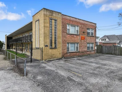 an aerial view of a city with lots of residential buildings and ocean view in back