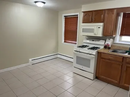 a kitchen with white cabinets and white appliances
