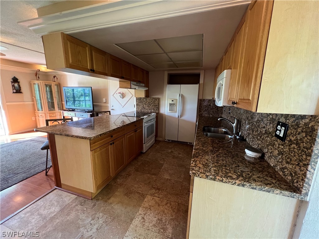1372 Archer Street, Unit 4 Lehigh Acres, FL 33936 - Photo 12 of 22 a kitchen with stainless steel appliances granite countertop a sink stove and refrigerator