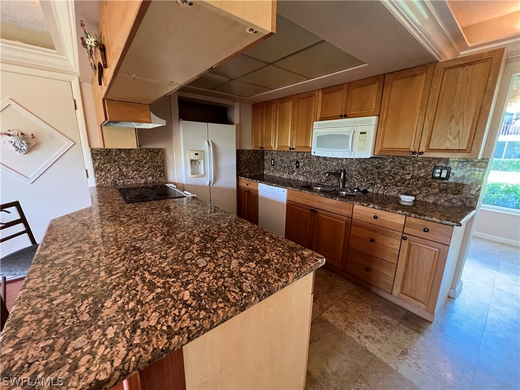 1372 Archer Street, Unit 4 Lehigh Acres, FL 33936 - Photo 13 of 22 a kitchen with a stove and a wooden cabinets