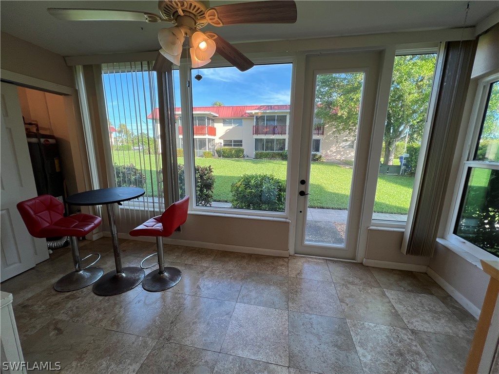 1372 Archer Street, Unit 4 Lehigh Acres, FL 33936 - Photo 14 of 22 a living room with furniture a floor to ceiling window and a flat screen tv