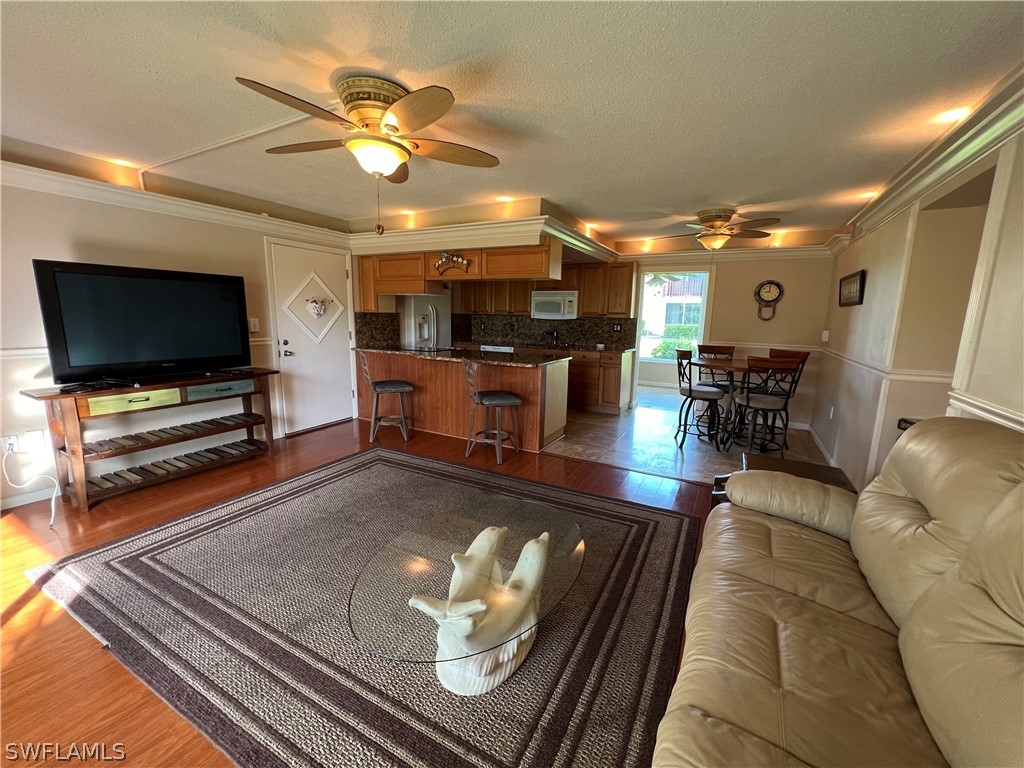 1372 Archer Street, Unit 4 Lehigh Acres, FL 33936 - Photo 17 of 22 a living room with furniture and a flat screen tv
