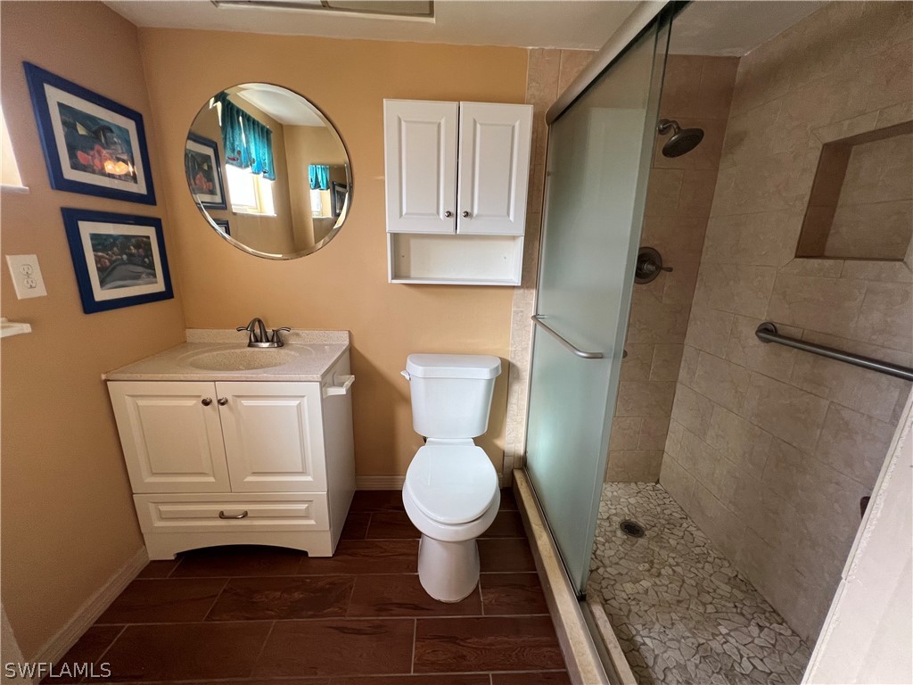 1372 Archer Street, Unit 4 Lehigh Acres, FL 33936 - Photo 20 of 22 a bathroom with a toilet sink and a mirror