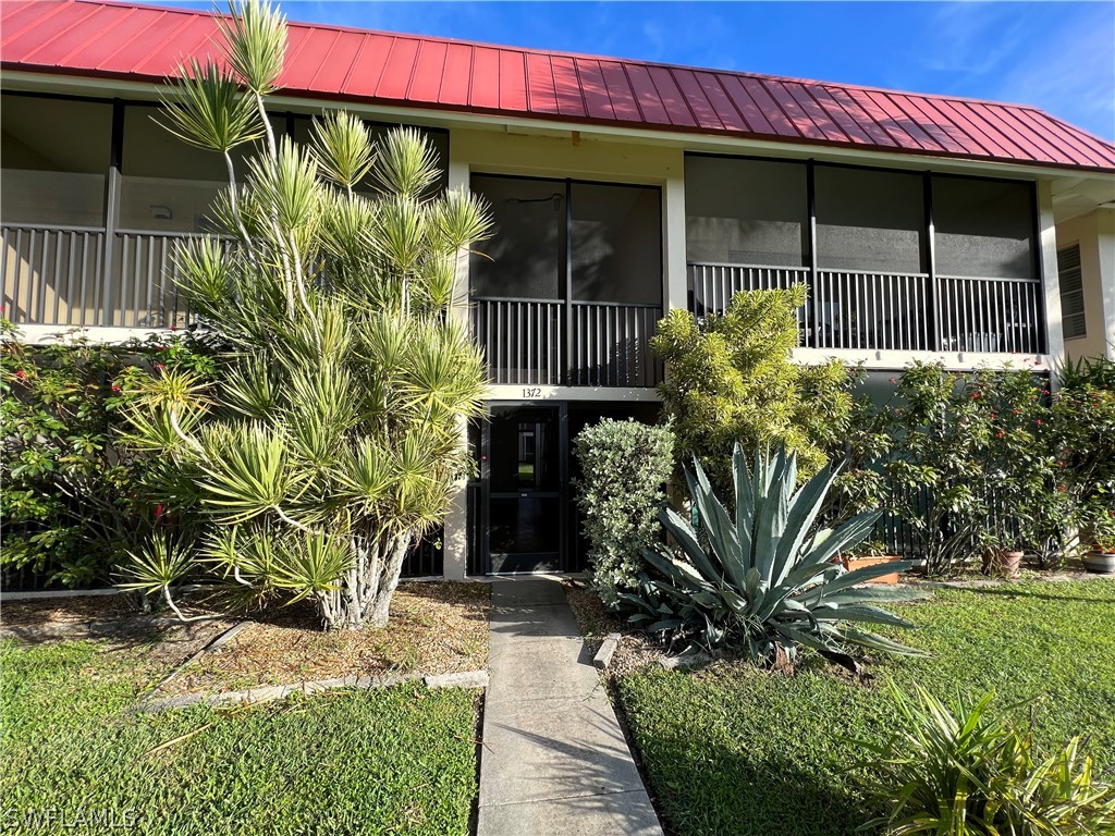 1372 Archer Street, Unit 4 Lehigh Acres, FL 33936 - Photo 2 of 22 a front view of a house with garden