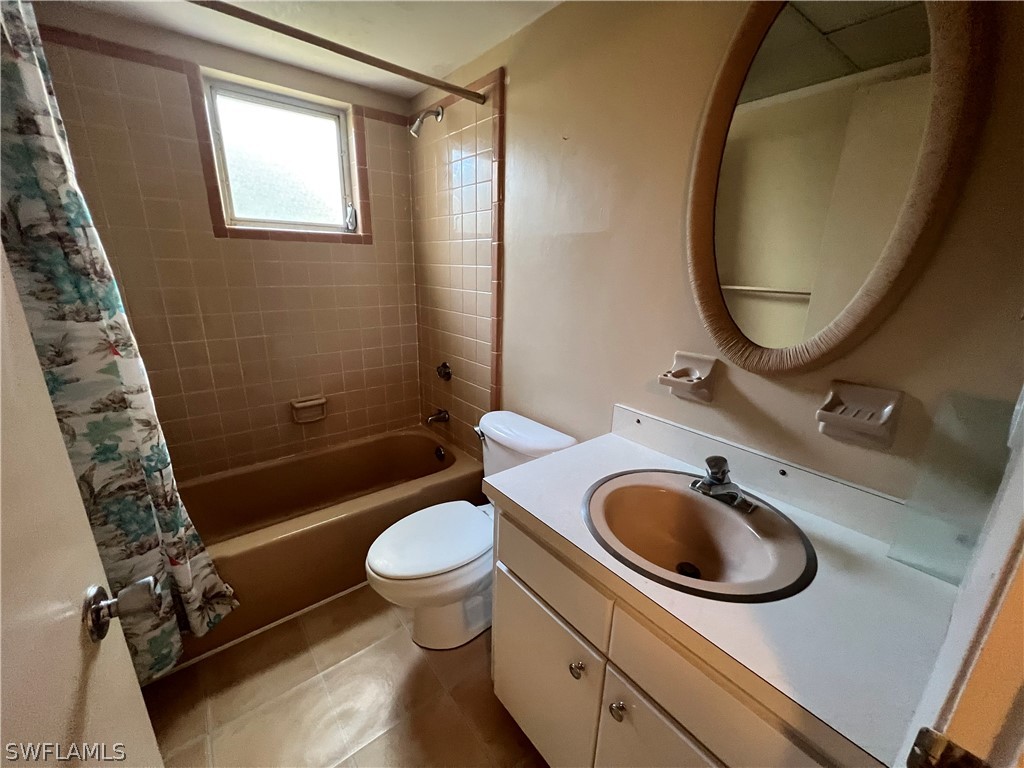 1372 Archer Street, Unit 4 Lehigh Acres, FL 33936 - Photo 22 of 22 a bathroom with a sink a toilet and a mirror