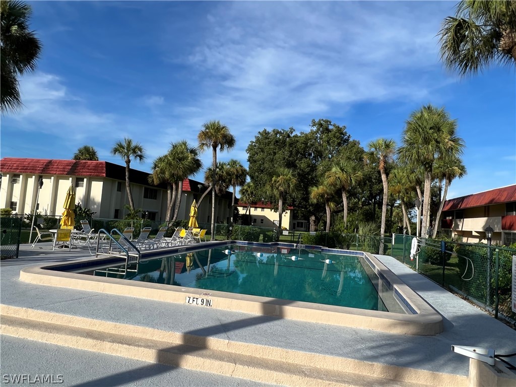 1372 Archer Street, Unit 4 Lehigh Acres, FL 33936 - Photo 4 of 22 a view of a swimming pool with a yard and palm trees