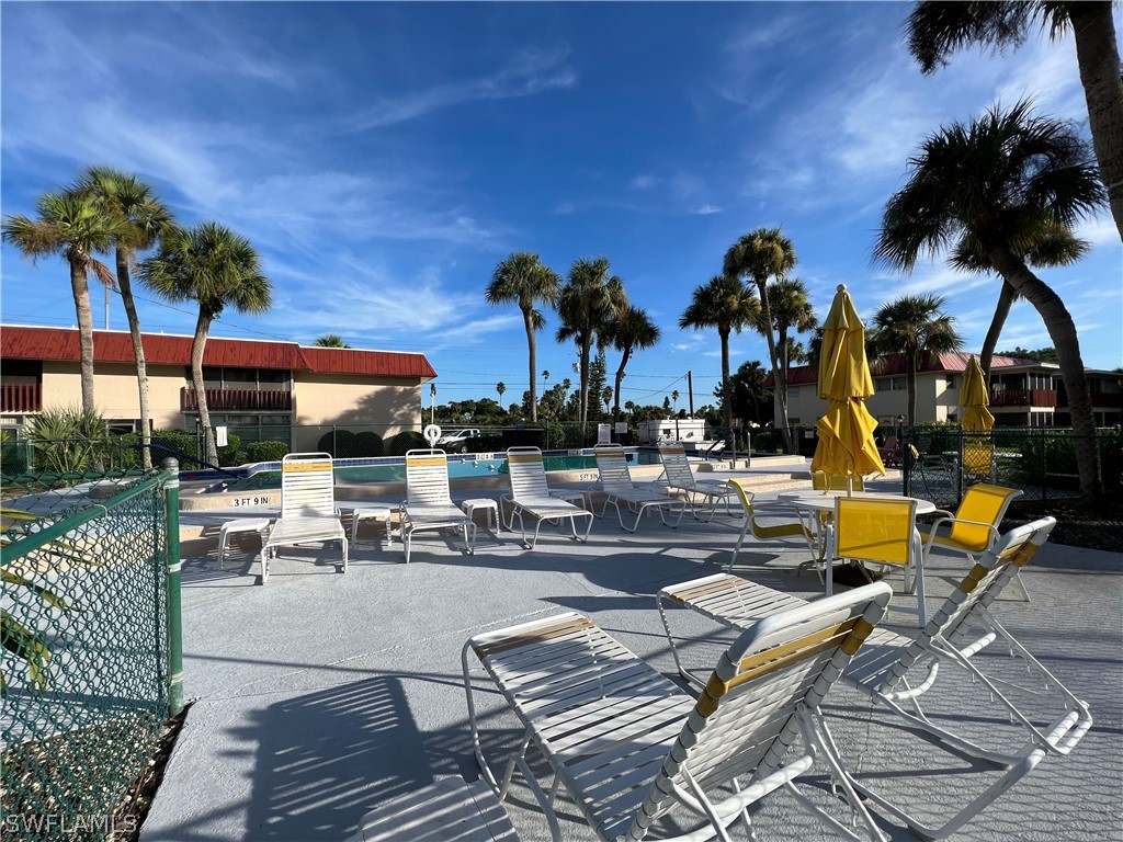 1372 Archer Street, Unit 4 Lehigh Acres, FL 33936 - Photo 5 of 22 a view of a patio with swimming pool table and chairs