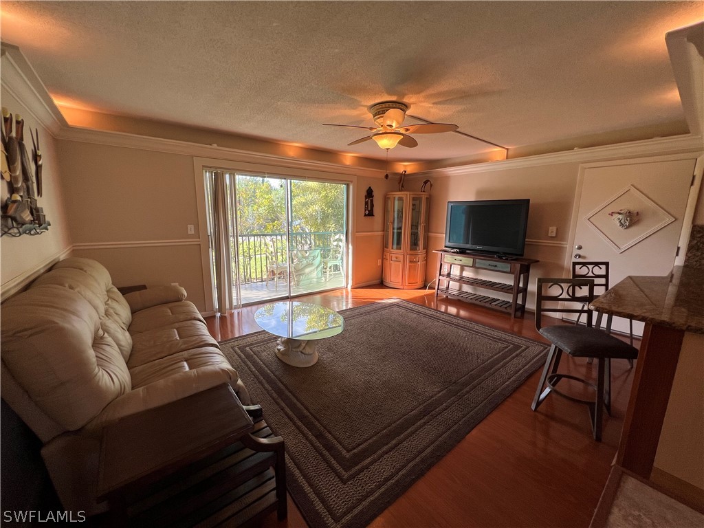 1372 Archer Street, Unit 4 Lehigh Acres, FL 33936 - Photo 8 of 22 a living room with furniture a flat screen tv and a chandelier