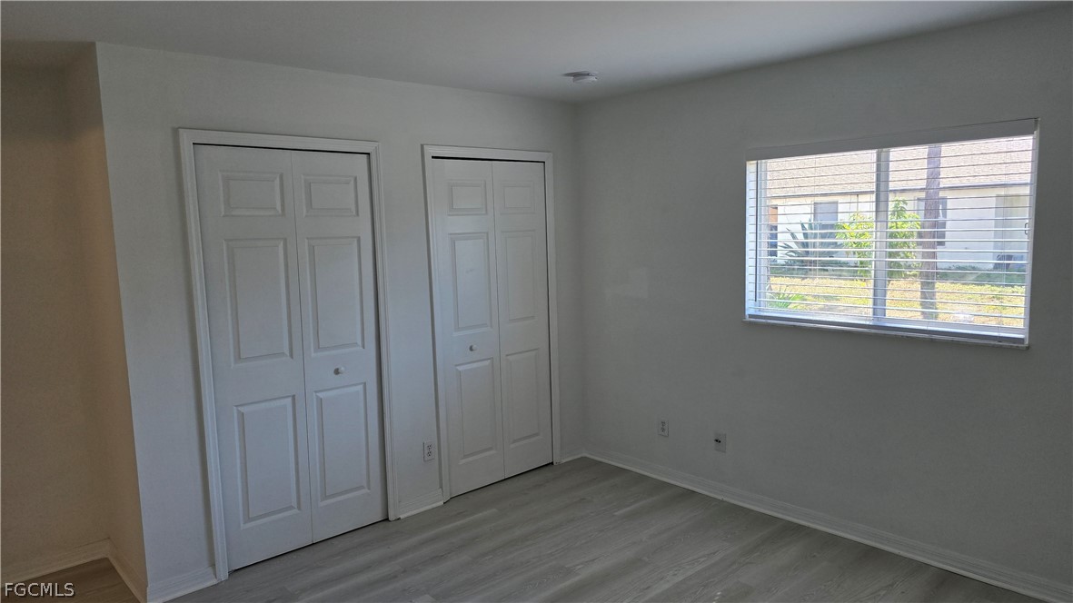 236-238 Peerless Street Lehigh Acres, FL 33974 - Photo 12 of 25 a view of an empty room with wooden floor and a window