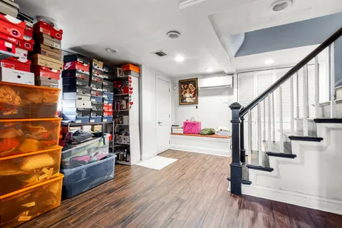 a room with lots of white furniture and a wooden floor