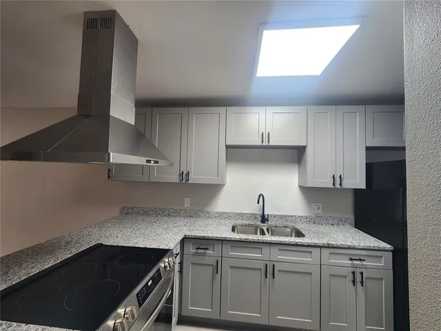 a kitchen with a sink a stove and cabinets