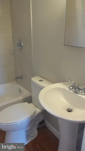 a white toilet sitting next to a bath tub