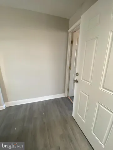 an empty room with wooden floor and mirror