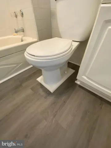 a white toilet sitting next to a bath tub