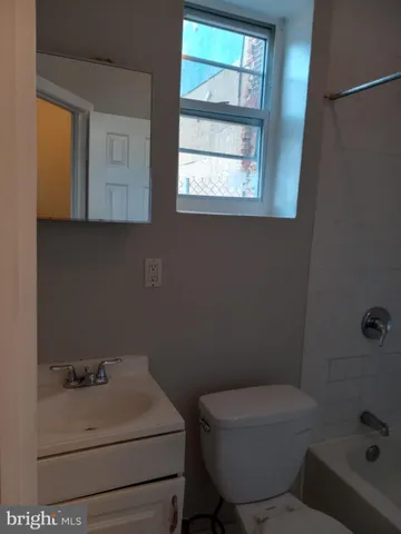 a bathroom with a sink toilet and window