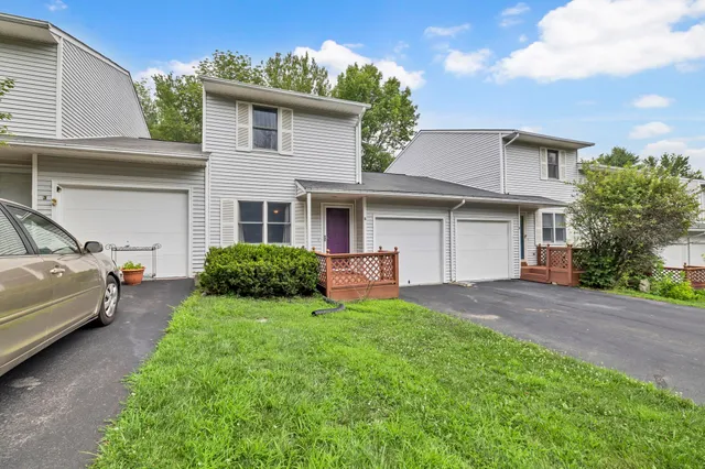 a view of a house with a yard and a large tree