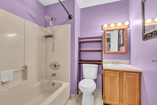 a bathroom with a bathtub sink vanity mirror and toilet