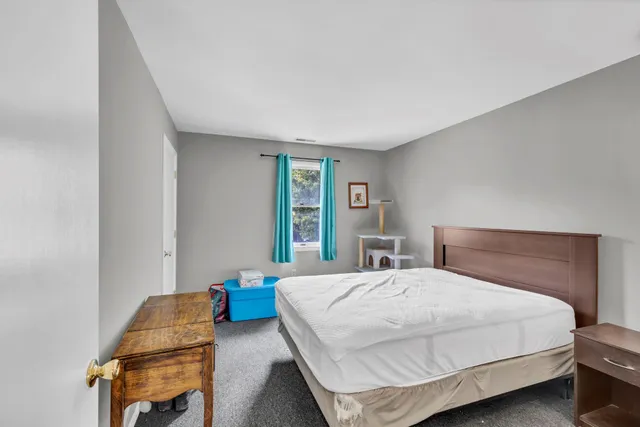 a bedroom with a bed chair and a window