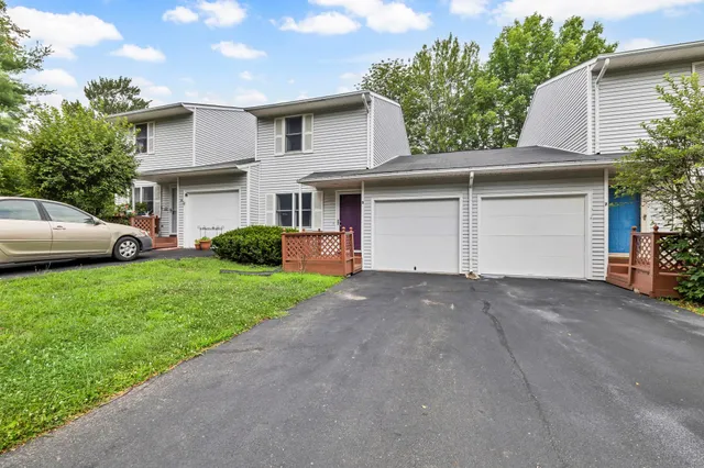 a view of a house with a yard and a garage