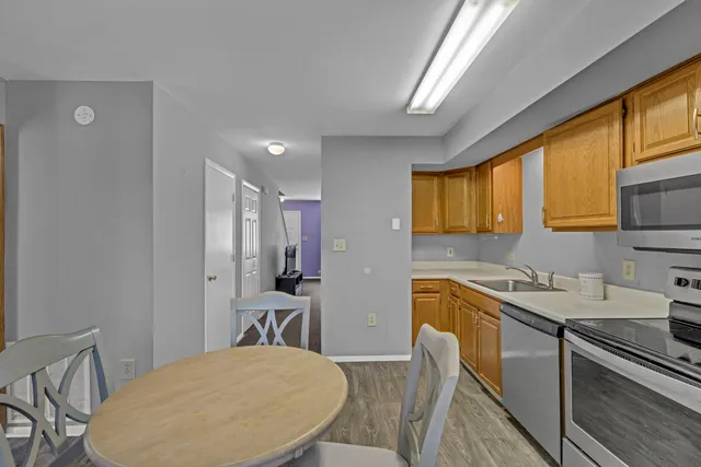 a kitchen with a table chairs refrigerator and microwave