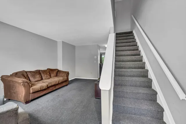 a living room with furniture and stairs