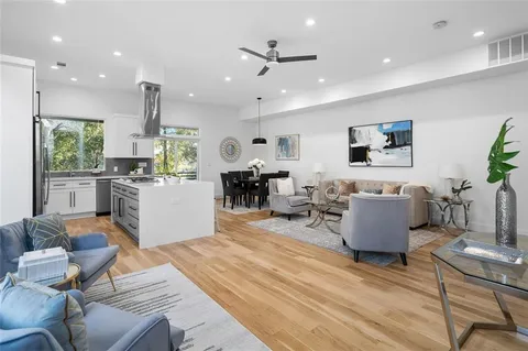 a living room with furniture kitchen view and a window
