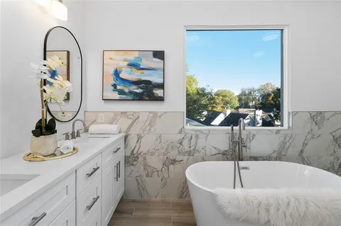 a bathroom with a tub and a painting on the wall