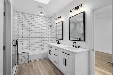 a bathroom with a double vanity sink a mirror and a shower