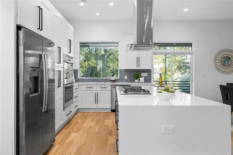 a kitchen with stainless steel appliances granite countertop a refrigerator sink and stove