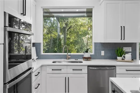 a kitchen with a sink window and cabinets