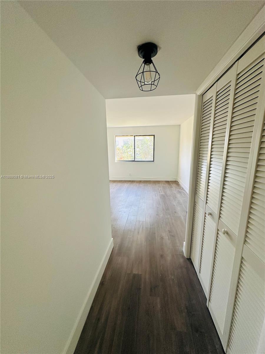 16491 Blatt Boulevard, Unit 202 Weston, FL 33326 - Photo 12 of 21 a view of a hallway with wooden floor and a chandelier