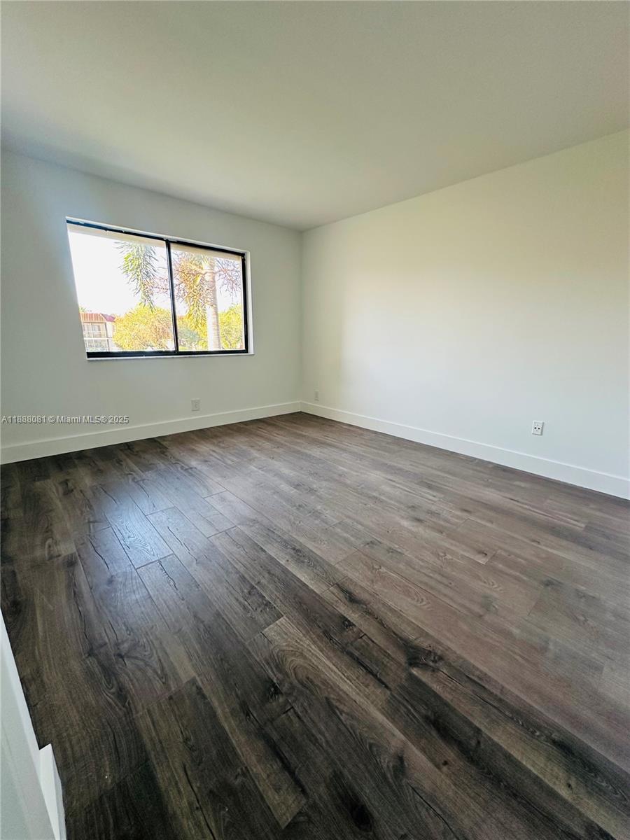 16491 Blatt Boulevard, Unit 202 Weston, FL 33326 - Photo 15 of 21 a view of an empty room with wooden floor and a window