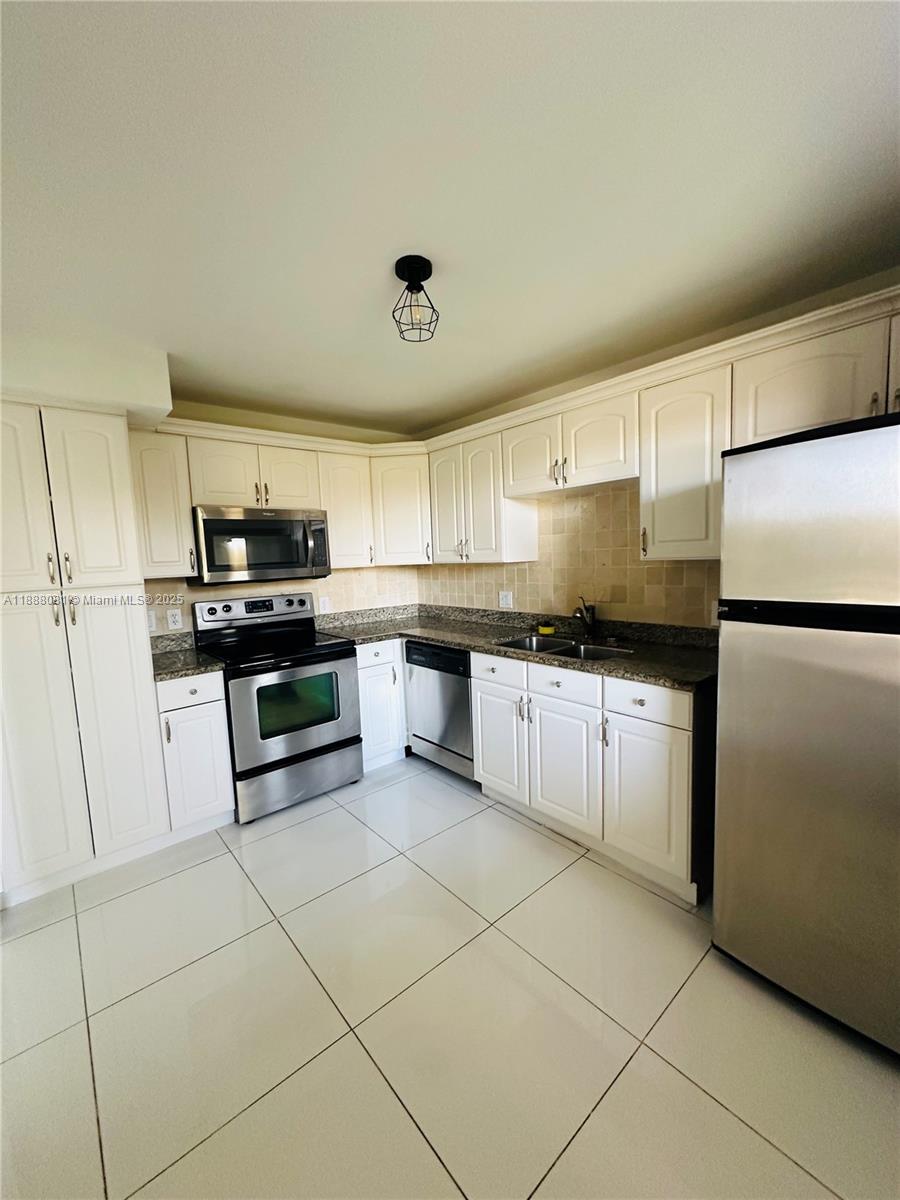 16491 Blatt Boulevard, Unit 202 Weston, FL 33326 - Photo 17 of 21 a kitchen with stainless steel appliances granite countertop a refrigerator and a stove top oven