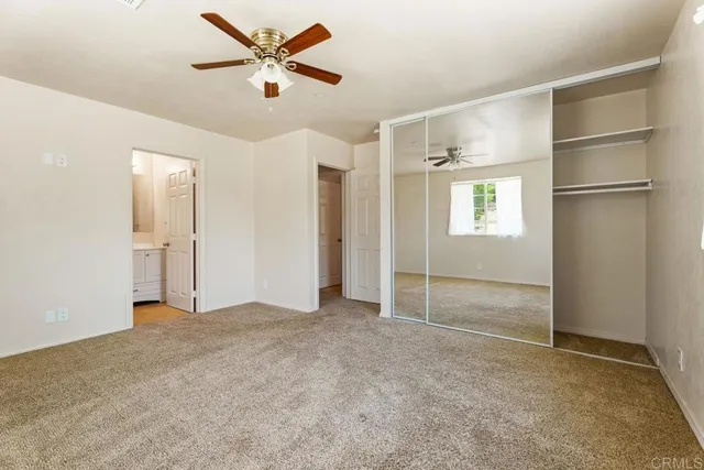 a view of an empty room with a ceiling fan