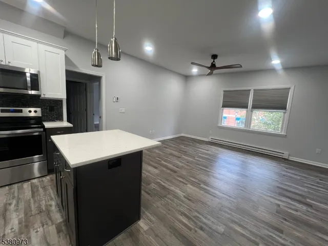 a kitchen with a refrigerator a sink and dishwasher with wooden floor