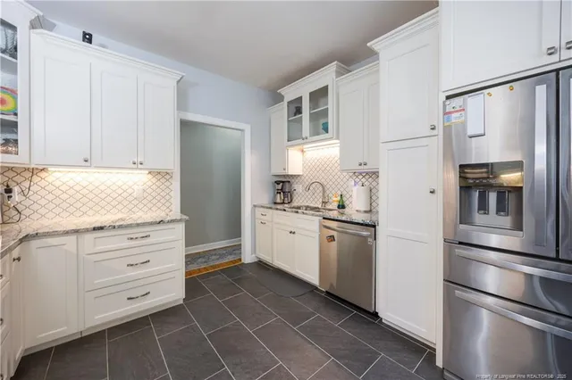 a kitchen with white cabinets and stainless steel appliances