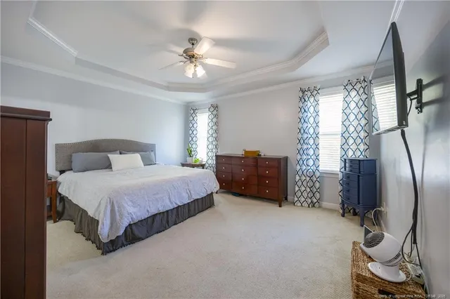 a spacious bedroom with a bed and a chandelier