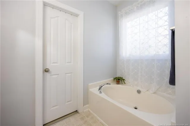 a white bath tub sitting next to a white cabinet