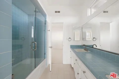 a spacious bathroom with a granite countertop sink mirror and shower
