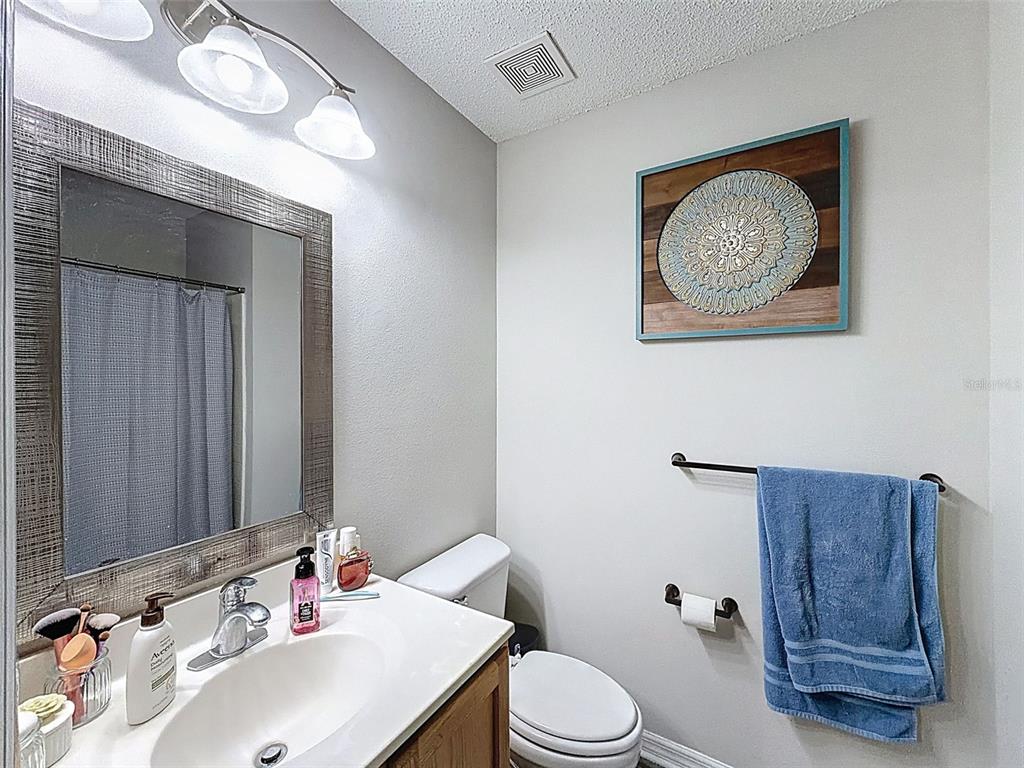 16061 Cave Swallow Road Brooksville, FL 34614 - Photo 29 of 47 a bathroom with a toilet a sink and mirror