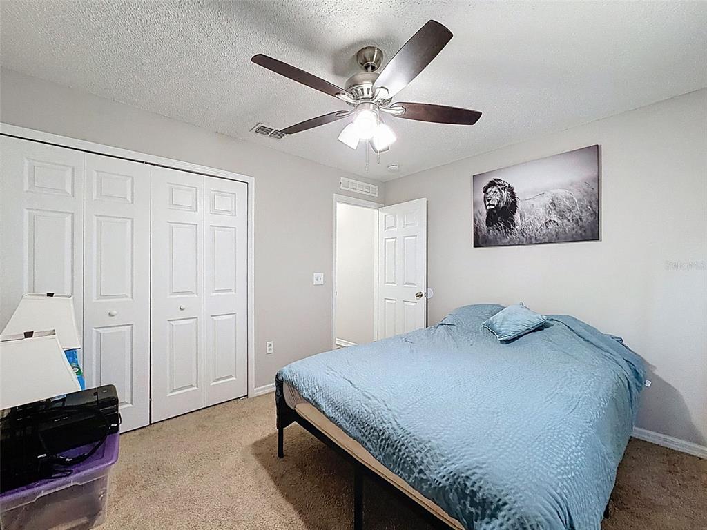 16061 Cave Swallow Road Brooksville, FL 34614 - Photo 33 of 47 a bedroom with a bed and a chandelier