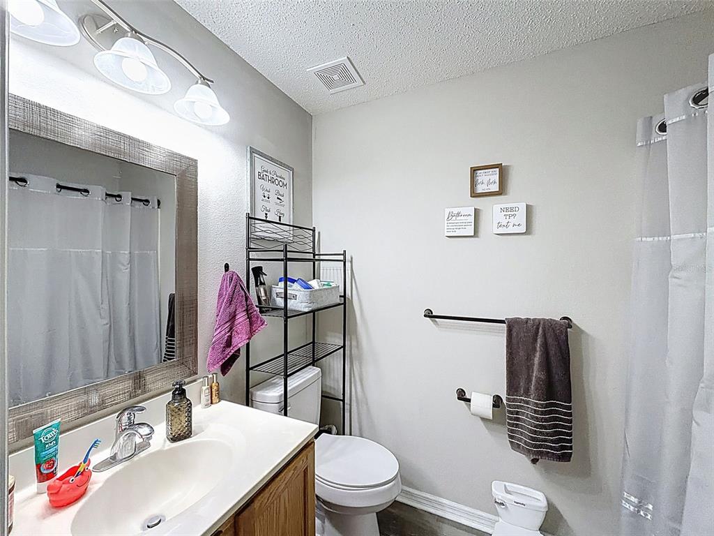 16061 Cave Swallow Road Brooksville, FL 34614 - Photo 36 of 47 a bathroom with a sink vanity mirror and toilet