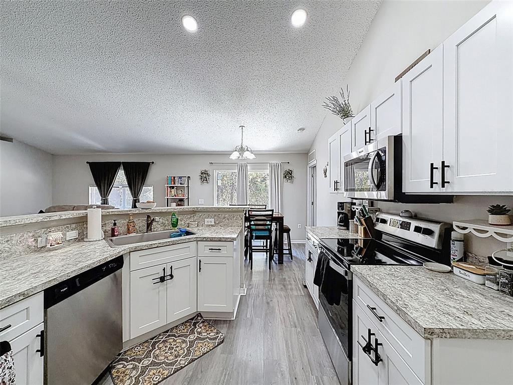 16061 Cave Swallow Road Brooksville, FL 34614 - Photo 4 of 47 a kitchen with stainless steel appliances granite countertop a lot of counter space and wooden floors