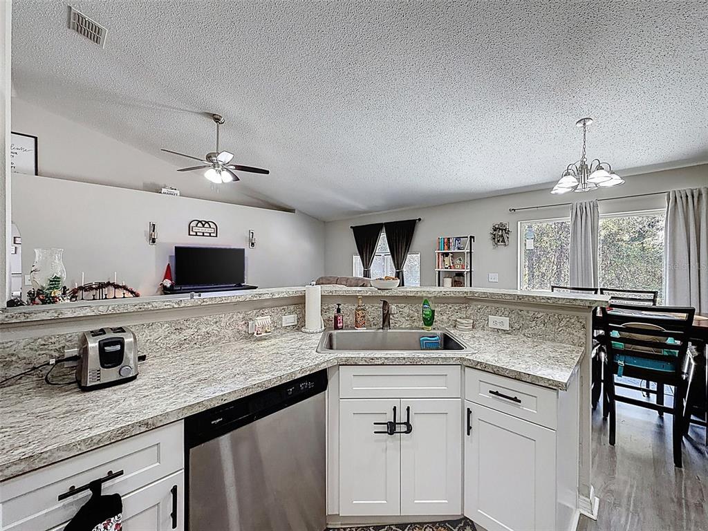 16061 Cave Swallow Road Brooksville, FL 34614 - Photo 6 of 47 a kitchen with kitchen island granite countertop a sink cabinets and window