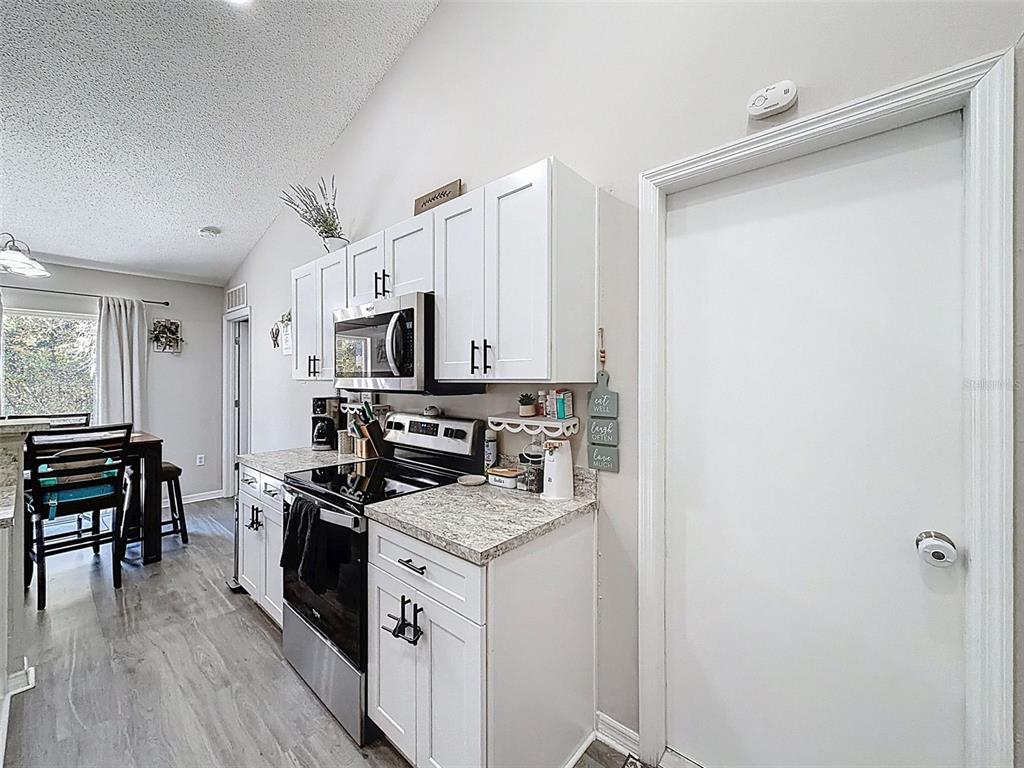 16061 Cave Swallow Road Brooksville, FL 34614 - Photo 8 of 47 a kitchen with a refrigerator stove and wooden floor