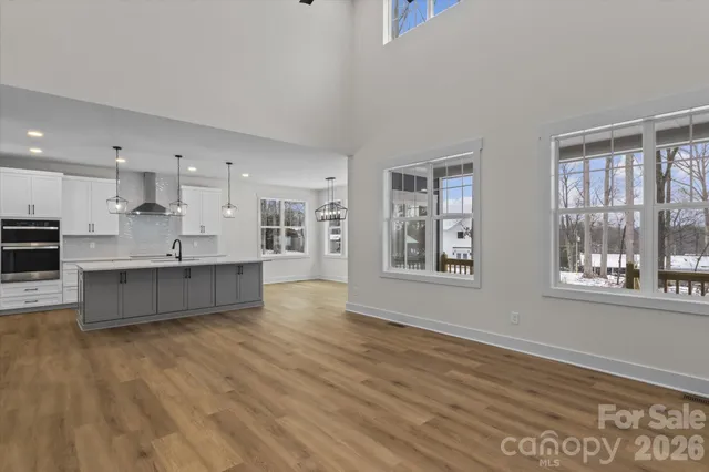 a large kitchen with stainless steel appliances kitchen island a large counter top and a wooden floors