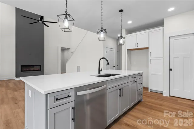 a kitchen with stainless steel appliances kitchen island a table chairs in it and wooden floors