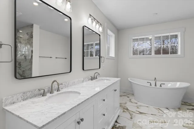 a bathroom with double vanity sinks a mirror and a shower