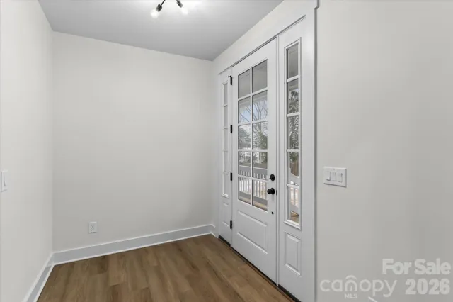 a view of room with walk in closet and wooden floor