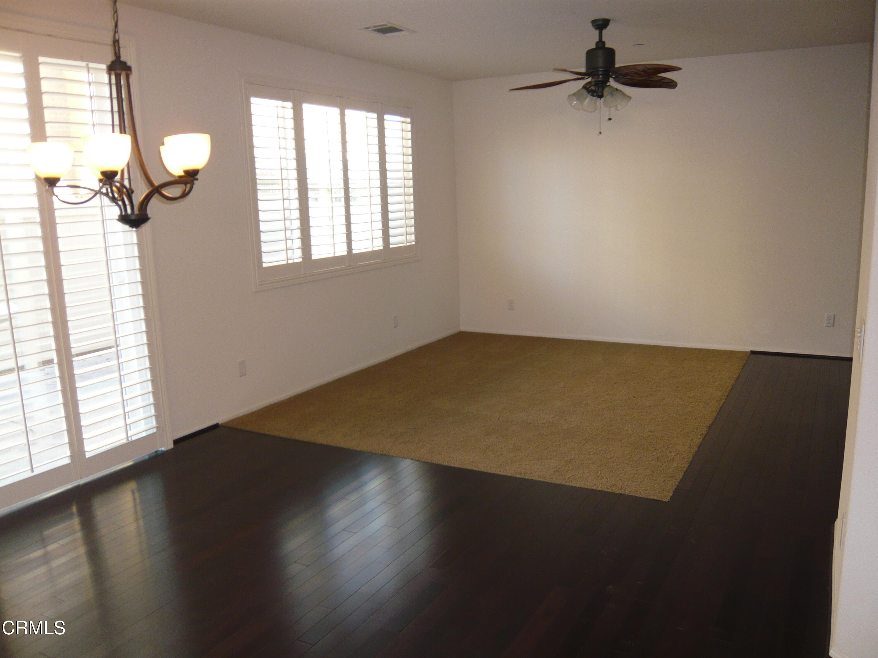 3754 Dunkirk Drive Oxnard, CA 93035 - Photo 5 of 16 an empty room with wooden floor fan and windows